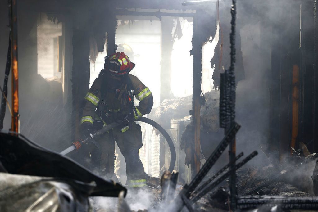 Spot News - 3rd place - Firefighters from several area departments battled a fire in a modified trailer on Oak Street in South Charleston. According to Madison Township Fire Chief Chris Clark, the home was fully involved when they arrived on the scene. He said the Red Cross was called for the two people who lived there and lost everything in the fire.  (Bill Lackey / Springfield News-Sun)