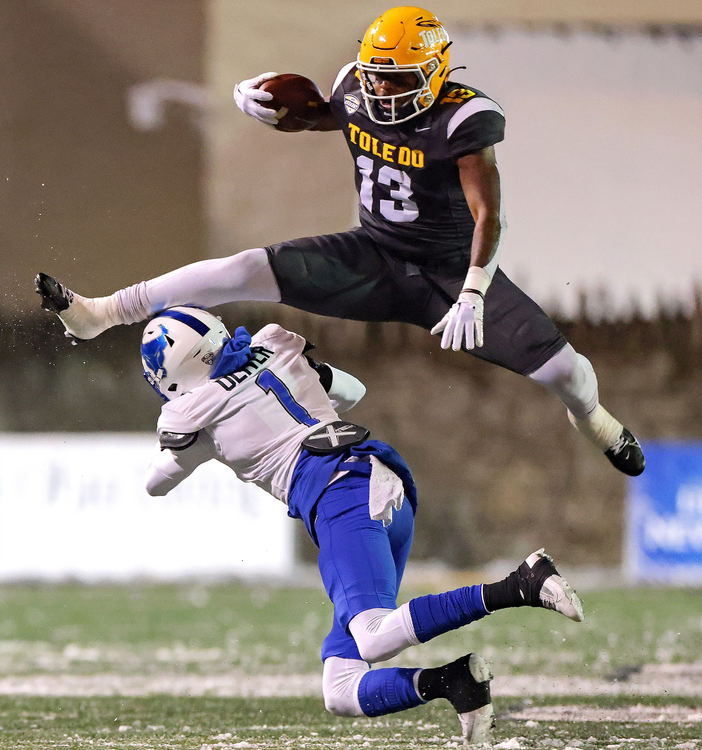 Sports - 3rd place - Toledo’s Peny Boone (top) hurdles Buffalo’s Jayden Oliver during a Mid-American Conference college football game at UT’s Glass Bowl in Toledo.  (Kurt Steiss / The Blade)