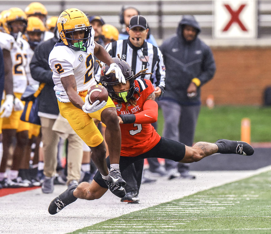 Sports - HM - University of Toledo wide receiver Junior Vandeross III stretches for extra yardage against  Ball State safety Jordan Riley at Scheumann Stadium in Muncie, Indiana.  (Jeremy Wadsworth / The Blade)