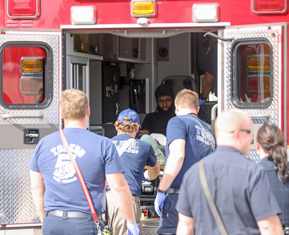 Story - 1st place - Darnell Peppers, 23 (center) is taken into an ambulance by Toledo Fire and Rescue personnel after he was grazed by bullet shot by a Toledo Police Department’s Officer Patrick Fischer after a chase that ended at the front door The Blade building in Toledo . Peppers dropped the gun in his hand after being grazed by Fischer’s bullet.  (Kurt Steiss / The Blade)