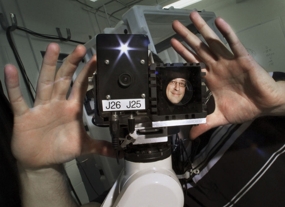 Portrait - 2nd place - Battelle engineer Joe Wagner with a robot he designed to inspect and repair the gas tank of B-52 bomber wings. Wagner is reflected in the input sensor of the robot arm that determines what is in front of it. (Neal C. Lauron / The Columbus Dispatch)