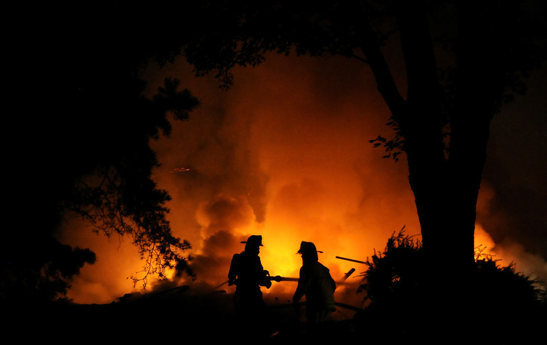 Spot News - 1st place - An apparently unoccupied house near the Clark, Miami and Montgomery county lines exploded. Investigators from the State Fire Marshal’s Office were on scene and were looking to the basement and furnace areas as the possible location of ignition.  (Marshall Gorby / Springfield News-Sun)