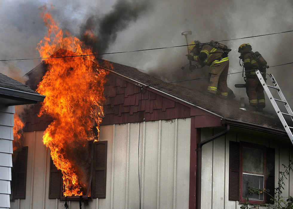 Spot News - 3rd place - Members of the Springfield Fire Division battle at house fire. Firefighters arrived on the scene to find heavy smoke and fire coming out of the roof and windows of the single story house. The residents of the house were not home at the time of the blaze. (Bill Lackey / Springfield News-Sun)