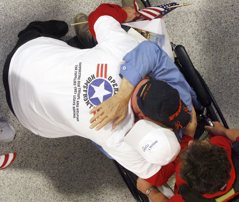 General News - 1st placeJamie Rhoads, originally from Canton and now living in Akron (top) embraces his grandfather John Hale Jr., of Zanesville, after Hale's Honor Flight returned to the Akron Canton Regional Airport. Both are veterans of the U.S. Navy. (Scott Heckel / The Repository)