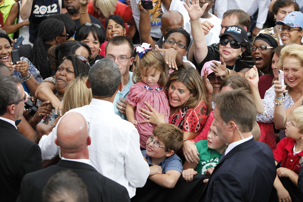 General News - HMJessica Hughes, of Hilliard, shields her three kids, including Julia, 3, Aidan, 8, and Evan, 6, from the rush of people rushing to shake hands with President Barack Obama after he spoke at a campaign rally in Schiller Park in the German Village neighborhood of Columbus .  (Adam Cairns / The Columbus Dispatch)