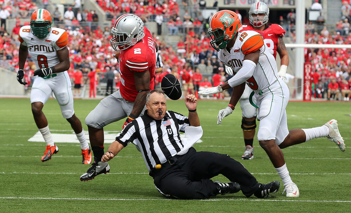 Sports - 1st placeOhio State running back Jordan Hall (2) tackles umpire Jim Krogstad  alongside Florida A&M defensive back Marshane Godbolt (15) in the second quarter at Ohio Stadium in Columbus. (Brooke LaValley / The Columbus Dispatch)