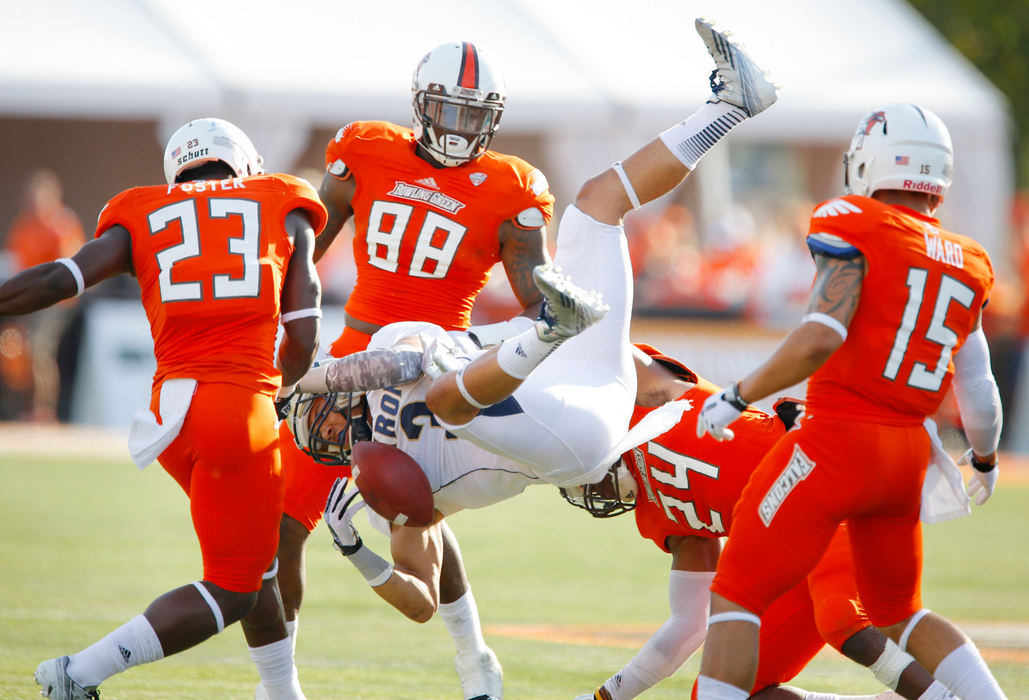 Sports - HMBowling Green's Jerry "Boo Boo" Gates (24) slams University of Akron's L.T. Smith (3) to the turf during the fourth quarter of their game in Bowling Green.  Gates was flagged for a penalty on the play.  (Andy Morrison / The Blade)