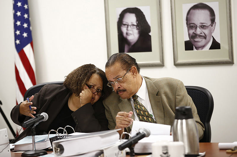 General News - 3rd place - Commissioner Delena Edwards (left) and commission president Grady L. Pettigrew whisper during the Civil Service Commission hearing for former Columbus firefighter Marc Cain after Cain's mistress testified. Cain requested the hearing to try to get his job back after being terminated in March for dishonest, insubordinate and sexual behavior.  (Eamon Queeney / The Columbus Dispatch)