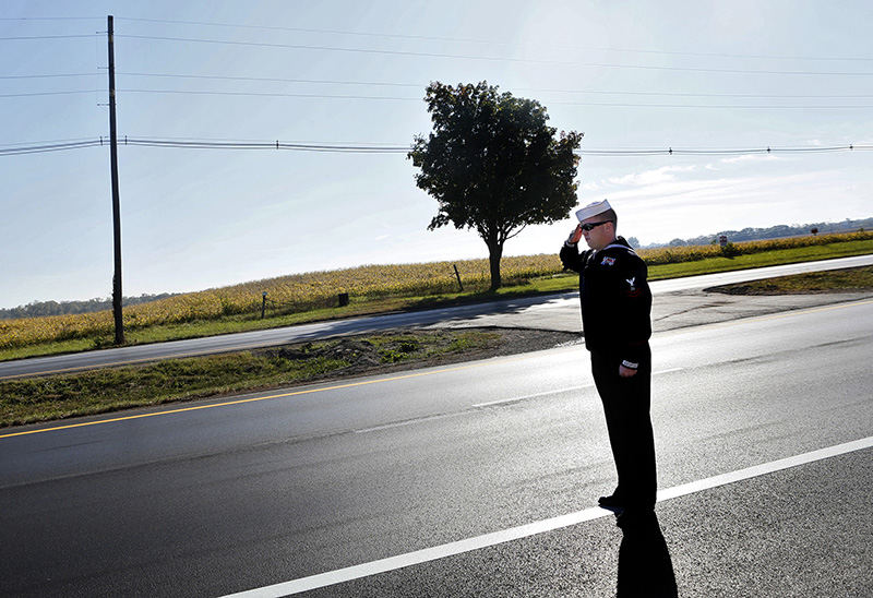 General News - HM - As the first police motorcycles pass by and clear Route 23 southbound lane outside of Columbus Navy reservist LS2 Bryan Brumfield of Grove City snaps to attention to salute the oncoming motorcade carrying  his friend and fellow reservist Lt. Stephen Byus who was killed in Afghanistan as it heads toward Wellston. Bryan had served in Iraq with Stephen and considered him a mentor. (Eric Albrecht / The Columbus Dispatch)