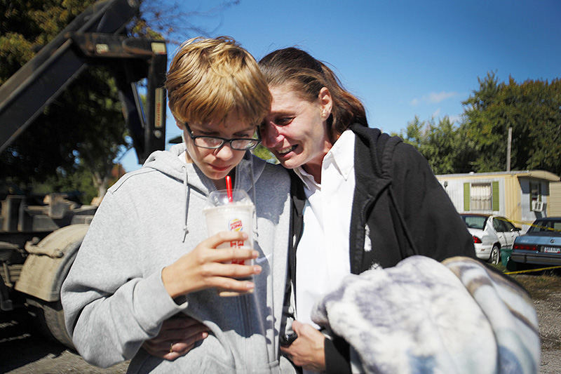 Spot News - 1st place - Ruby Lynch rests her head on the shoulder of her son, Bobby, 14, as the remains of their home is demolished following an early morning fire that killed her husband and Bobby's father, Robert J. Lynch II, at Oster's Mobile Home Park in Huron. (Angela Wilhelm / Sandusky Register)