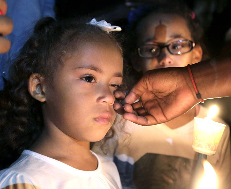 General News - 1st place - Tamya Thomas has her tears wiped away as her sister Anya Thomas looks on during a vigil in Canton for their late father, Derico Rodriques Thomas, who was shot and killed outside the night club, Movement. (Scott Heckel / The (Canton) Repository)