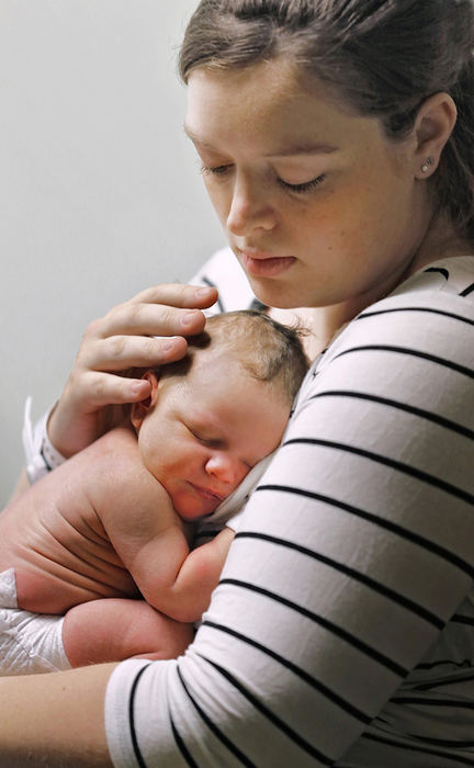 Portrait - 1st place - Sarah Sims holds her newborn baby, Liam Atlas, in her room at the Ohio State University Wexner Medical Center.  She and her husband sought the services of a midwife for their birth experience.   (Chris Russell / The Columbus Dispatch )