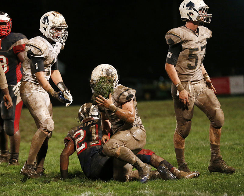 Sports Feature - HM - Jake Purdy (25) of Granville comes up with a piece of turf stuck in his face mask after tackling Tyion Atkins (21) of Eastmoor Academy.  (Barbara J. Perenic / The Columbus Dispatch)