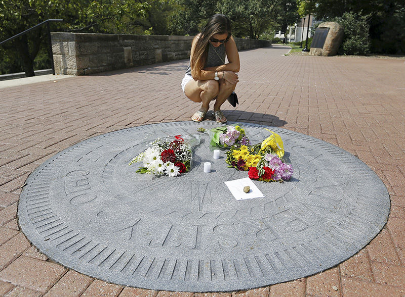 ASpot News - 1st place - After finding out about the death of classmate Wendell Jackson, Meghan Tenorio, 20, places flowers on the Denison University seal in front of Swasey Chapel on the school's campus. Tenorio said she didn't know Jackson well, but she saw him almost every day and his smile brought joy to everyone. Jackson's body was found near the campus Tuesday morning.  (Adam Cairns / The Columbus Dispatch)