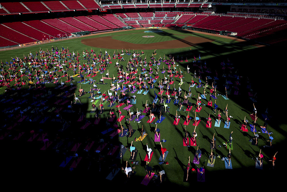 Feature - 2nd place - More than 500 people participate in an hour-long yoga session instructed by The Yoga Bar on the outfield grass at Great American Ball Park for "Sliding Into Om."  (Meg Vogel / Cincinnati Enquirer)