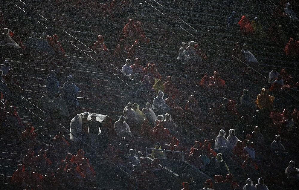 SSports Feature - 2nd place - Fans in C-Deck try to stay dry during the third quarter of a football game between Ohio State and Tulsa at Ohio Stadium. (Jonathan Quilter / The Columbus Dispatch)