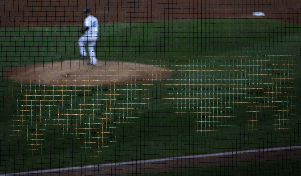 SSports Feature - HM - Shadows of fans are cast on the net above the home dugout as Columbus Clippers pitcher Adam Plutko (28) prepares to deliver a pitch in the first inning during the first game of the Governors' Cup Playoffs between the Columbus Clippers and the Gwinnett Braves at Huntington Park. (Jonathan Quilter / The Columbus Dispatch)