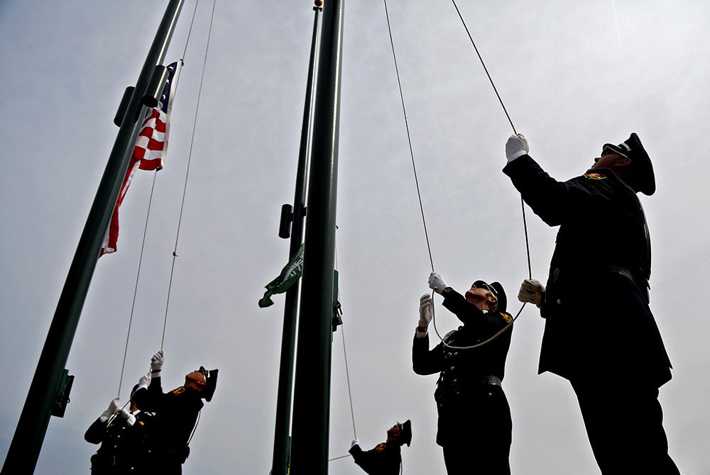 General News - 1st place - The Westerville Police Honor Guard raise the flags during the playing of the Pledge of Allegiance during the community's September 11th memorial service at First Responders Park. (Kyle Robertson / The Columbus Dispatch)