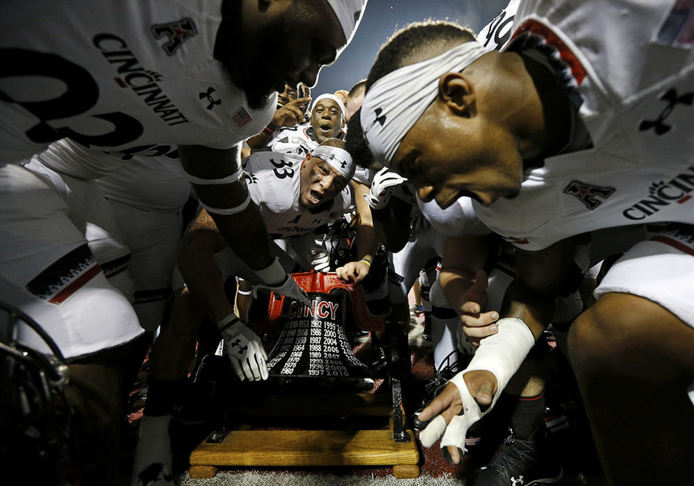 SSports Feature - 1st place - The Cincinnati Bearcats celebrate with the Victory Bell after defeating the Miami Redhawks at Yager Stadium in Oxford. The Bearcats won 21-17 after an intercepted RedHawks pass was returned for a touchdown with just over one minute remaining in the game.  (Sam Greene / Cincinnati Enquirer)