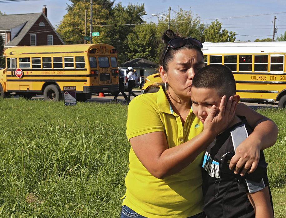 MT Spot News - 1st place - A parent reunites with her son across from Scioto High School on S. High St. in Columbus after Columbus Police arrested a student who was armed with a gun and discharged it in the hallway. (Eric Albrecht / The Columbus Dispatch)