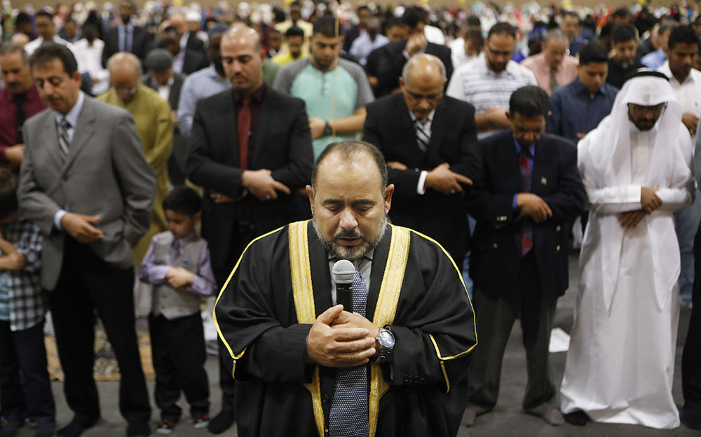 Story - 2nd place - Imam Farooq Aboelzhab leads prayer as area mosques celebrate Eid Al-Adha at the SeaGate Convention Centre.  Eid al-Adha, also known as the Feast of the Sacrifice, recalls Abraham’s willingness to sacrifice his son as an act of obedience to God, who in turn sent an angel to place a ram in Ismail’s stead. It also commemorates the hajj, an annual pilgrimage to Mecca. (Andy Morrison / The Blade)