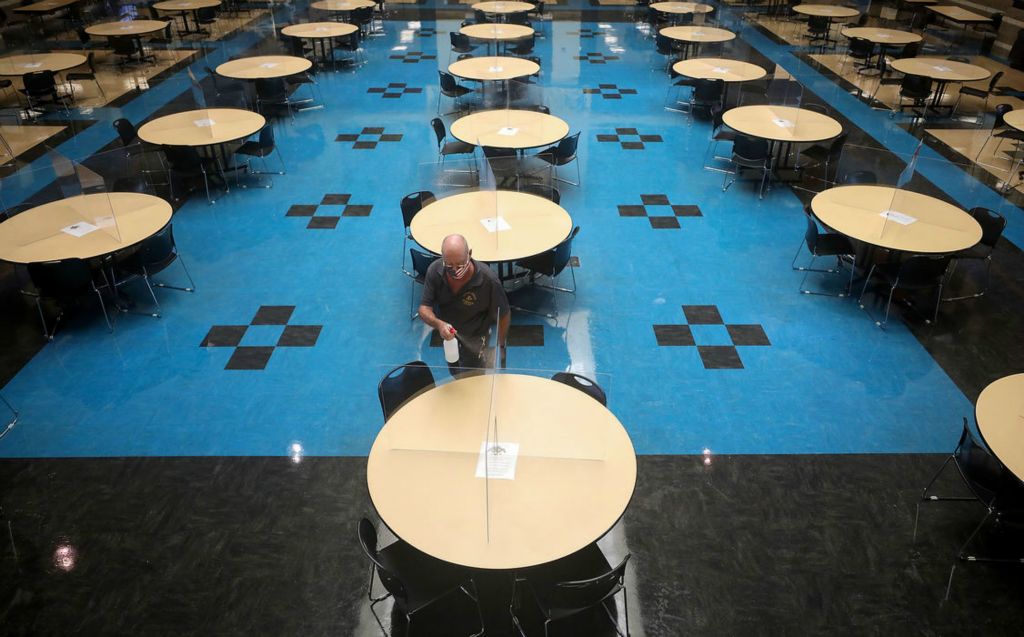 General News - 1st place - Dan Sprague, custodian, sprays dividers on tables with disinfectant between lunches at Perrysburg High School.(Kurt Steiss / The Blade)