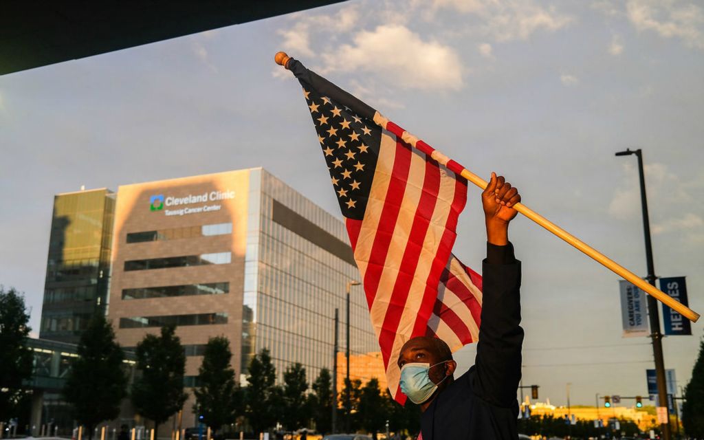 General News - 2nd place - Darius Mitchell, who is running for president as a write-in candidate, waves the American Flag prior to the first presidential debate between President Donald Trump and former Vice President Joe Biden in Cleveland.  (Jeremy Wadsworth / The Blade)