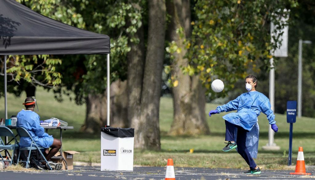 General News - 3rd place - A member of the National Guard kicks a ball around between administering coronavirus tests at Scott Park in Toledo where the National Guard and the Lucas County Health Department held a pop up testing site.(Jeremy Wadsworth / The Blade)