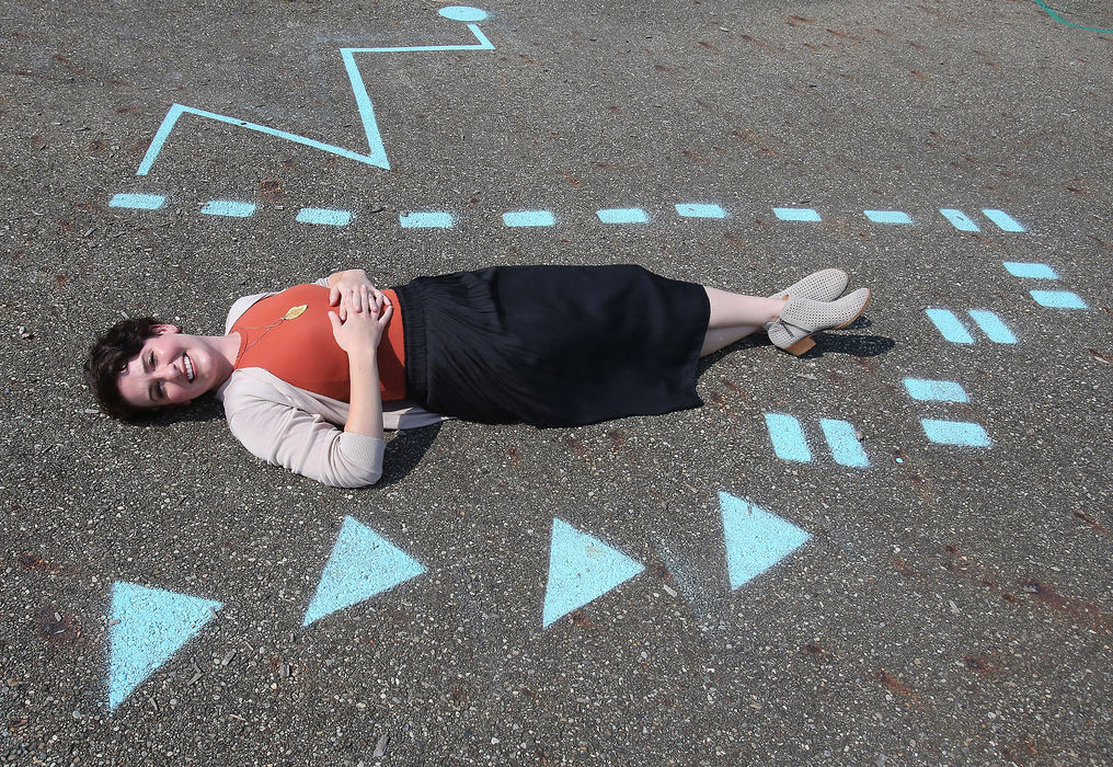 Portrait - 3rd place - Shannon Clokey an art teacher at Tuslaw Elementary School is shown with one the sensory paths she painted with the help of others on the school's playground.(Scott Heckel / The Repository)