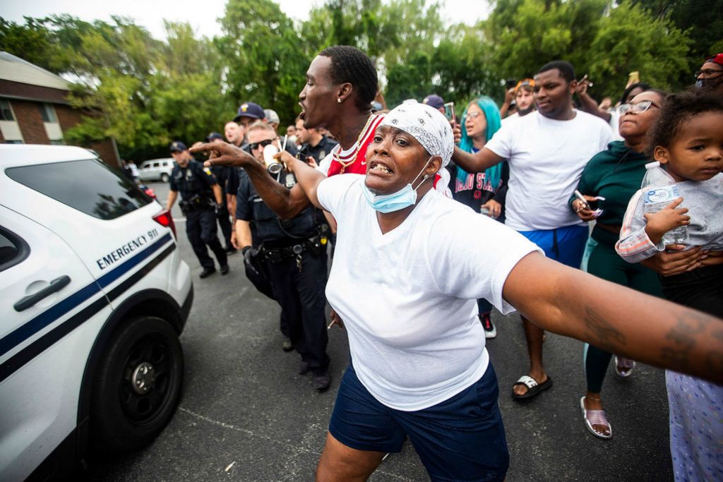 Spot News - 1st place - Sherri Sweeney, a volunteer searcher, holds back people as they rush the police car carrying Dajnae Cox, the mother of 3-year-old Braylen Noble, after his body was found in the apartment pool at Hunter's Ridge Apartments in Toledo.(Rebecca Benson / The Blade)