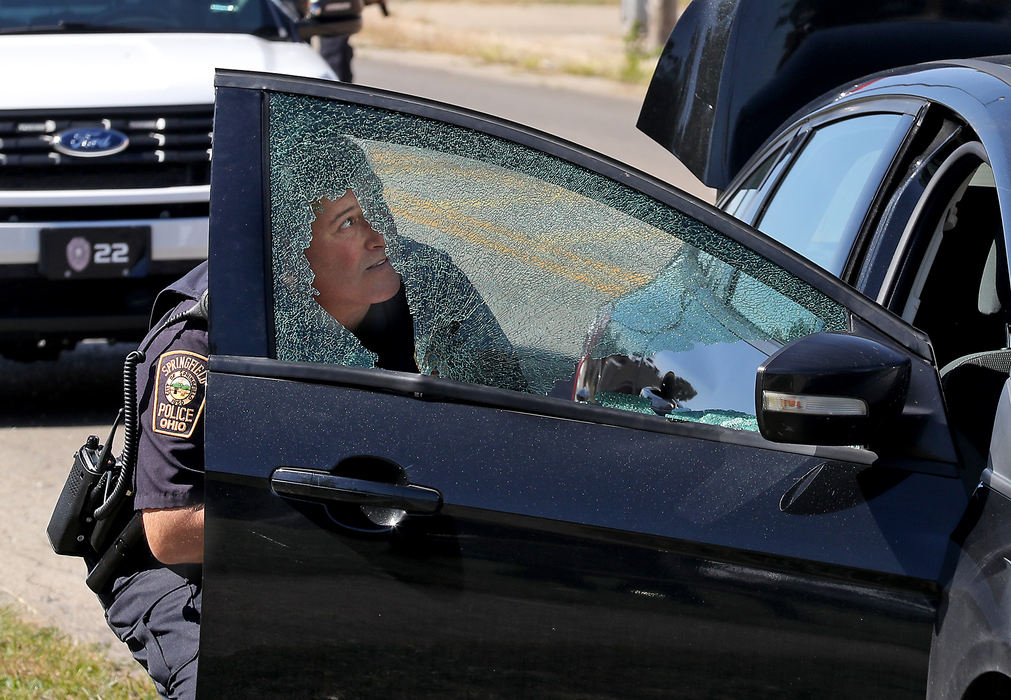 Spot News - 3rd placeA Springfield police officer is seen through the shattered window of a car that was traveling east of West Main Street when the driver was shot in the arm by the driver of another car. The bullet traveled through the drivers arm and shattered the passenger window. Police are still looking for the shooter.  (Bill Lackey / Springfield News-Sun)