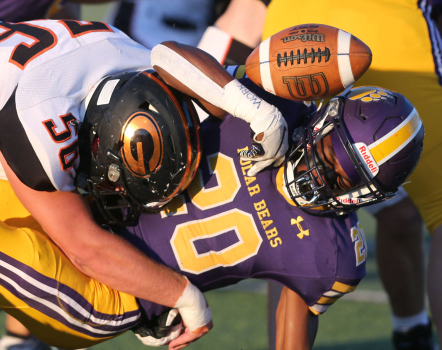 Sports - 1st place - Brenden Craig, 20, of Jackson fumbles after being hit by Garrett Dennis, 56, of Green during their game at Jackson High School. (Scott Heckel / )