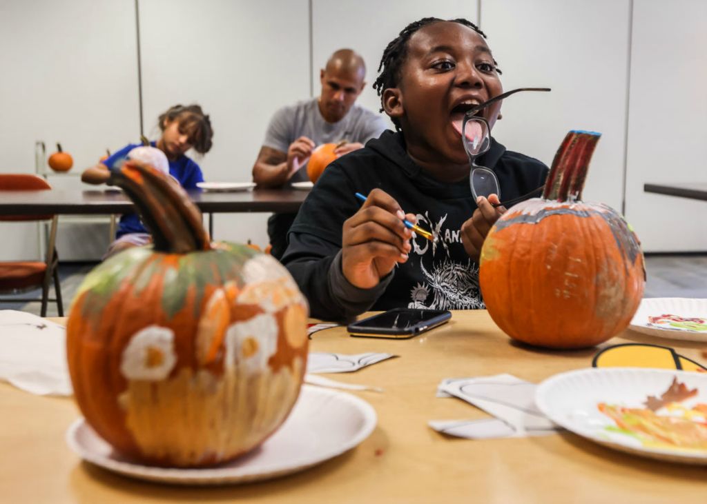 Feature - 2nd place - Toledo resident Garland Grover, 10, licks grey paint from his glasses while decorating a pumpkin at Washington Branch Library in Toledo. (Isaac Ritchey / The Blade)