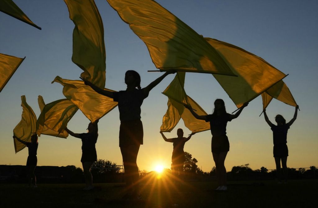 Feature - HM - The Hilliard Bradley color guard warms up at sunset before performing at halftime during a game against Hilliard Darby. (Barbara J. Perenic / The Columbus Dispatch)