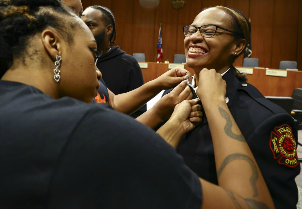 General News - 1st place - Komako Goolsby, the first African-American woman to be promoted to the Rank of Captain in the Toledo Fire Department, is pinned by family members at One Government Center in Toledo.   (Jeremy Wadsworth / The Blade)