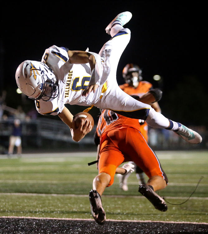 Sports - 3rd place - Tallmadge quarterback Ty Hurst is upended by Green defensive back Anthony Fortunato as he scores the game-winning two-point conversion in overtime. (Jeff Lange / Akron Beacon Journal)