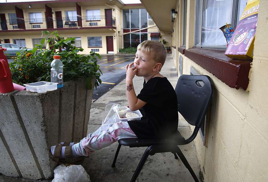 Feature - 2nd place - Colton Park, 3, enjoys his Lunchable while sitting outside his family's room at the Executive Inn homeless shelter. According to Colton's mother, they have been staying at the shelter for two weeks, since they were evicted from their apartment. Colton was eating outside because residents are not allowed to eat in their rooms. (Bill Lackey / Springfield News-Sun)