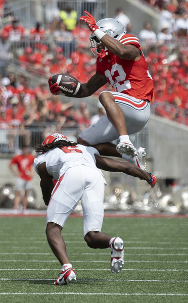 Sports - 3rd place - Ohio State running back TreVeyon Henderson (32) leaps over Youngstown State defensive back Ezekiel Blake (6) after gaining a few yards in the second quarter of their game at Ohio Stadium.  (Brooke LaValley / The Columbus Dispatch)