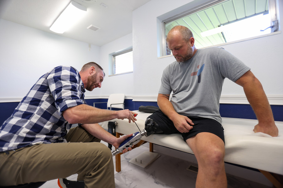 Story - 2nd place - Bryan Sculthorpe, Certified Orthotist Prosthetist, adjusts Josh Green’s, an Amputee Care and Outreach Specialist, prosthetic at the Cole Leimkuehler Orthotic-Prosthetic Center in Toledo.  (Jonathan Aguilar / The Blade)