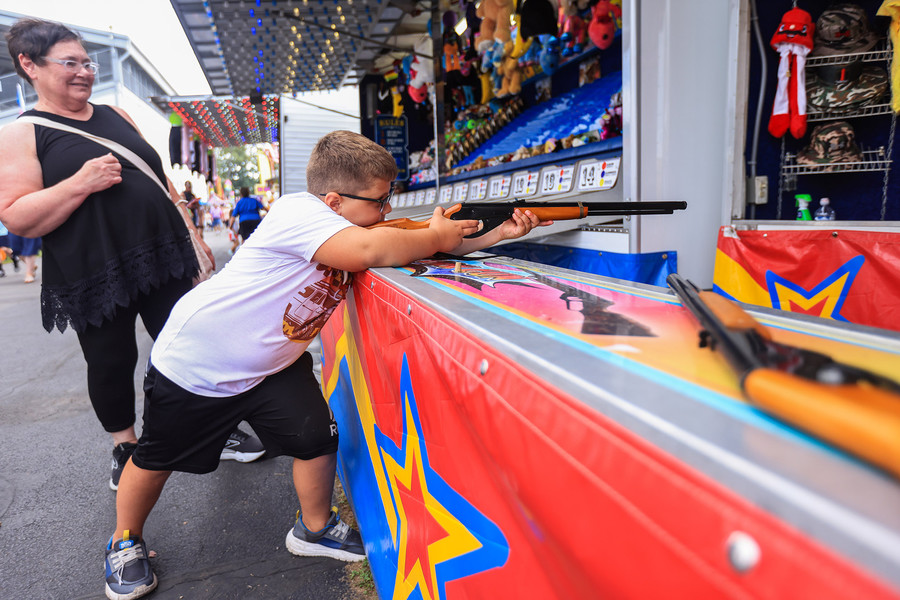 Story - 3rd place - Seven-year-old Lincoln Ferner aims a cork gun at a wall of cups to win a prize at the Fulton Country Fair in Wauseon. (Rebecca Benson / The Blade)