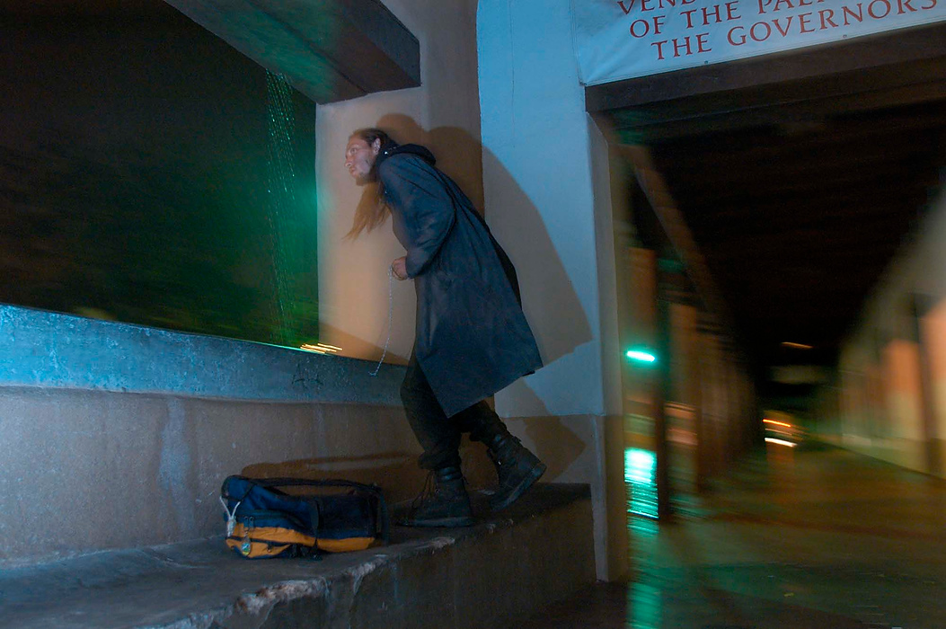 Second place, Larry Fullerton Photojournalism Scholarship - Erin Galletta / Kent State UniversitySatan, a 25-year-old homeless man, peeks out into the rain from the portal in downtown Santa Fe. He spent the evening moving from one bench to another to avoid a hassle from the police for loitering.