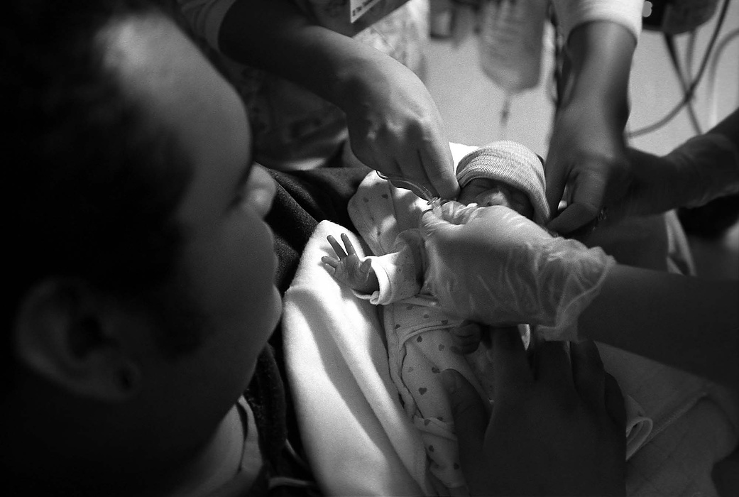 First place, Larry Fullerton Photojournalism Scholarship - Lindsay Steiner / Ohio UniversityRicky watches as nurses transfer Isabella from her bed to his arms.  She can go home when she can bottle-feed her eight meals a day without difficulty.  She can drink three bottles easily now, and is improving daily. 