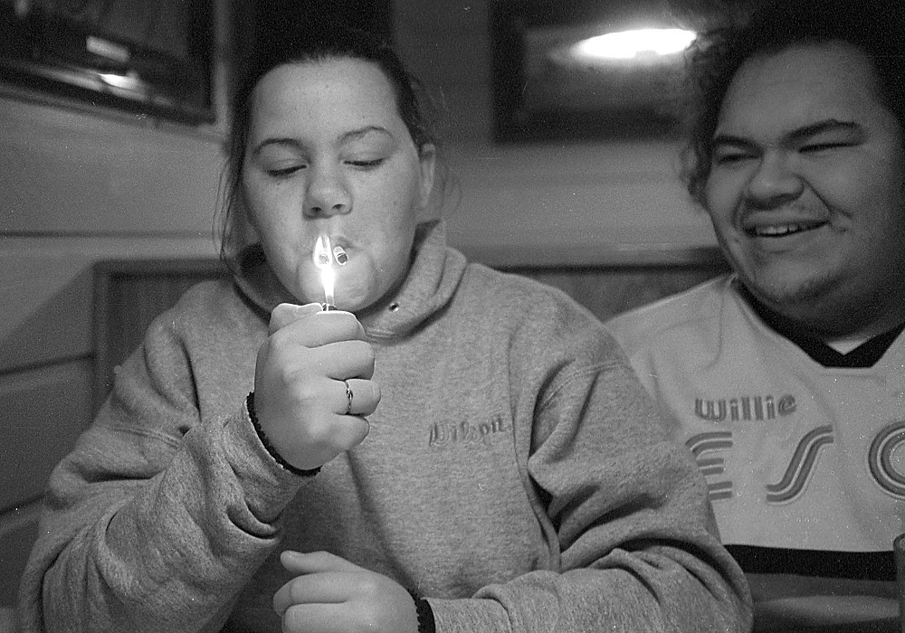 First place, Larry Fullerton Photojournalism Scholarship - Lindsay Steiner / Ohio UniversityCasi lights two cigarettes at once while she spends an evening with Ricky at Pizza Hut.  The two first met while working at this Pizza Hut; Casi still works here part time, while Ricky works at an auto repair shop.  Casi plans on returning to school after Christmas break, but for now she will work and take care of Isabella. 