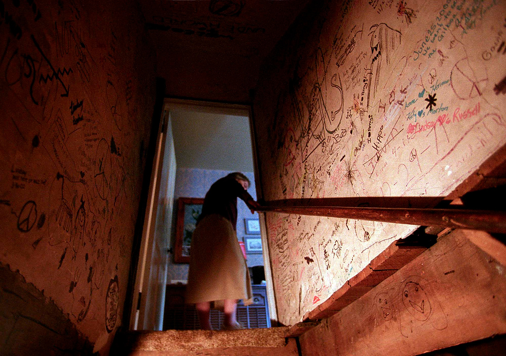 First place, Larry Fullerton Photojournalism Scholarship - Lindsay Steiner / Ohio UniversityMargaret walks up her basement stairs after retrieving some walnuts to feed the squirrels.  The walls of the basement stairwell are covered in graffiti written by various family members at one time or another.  