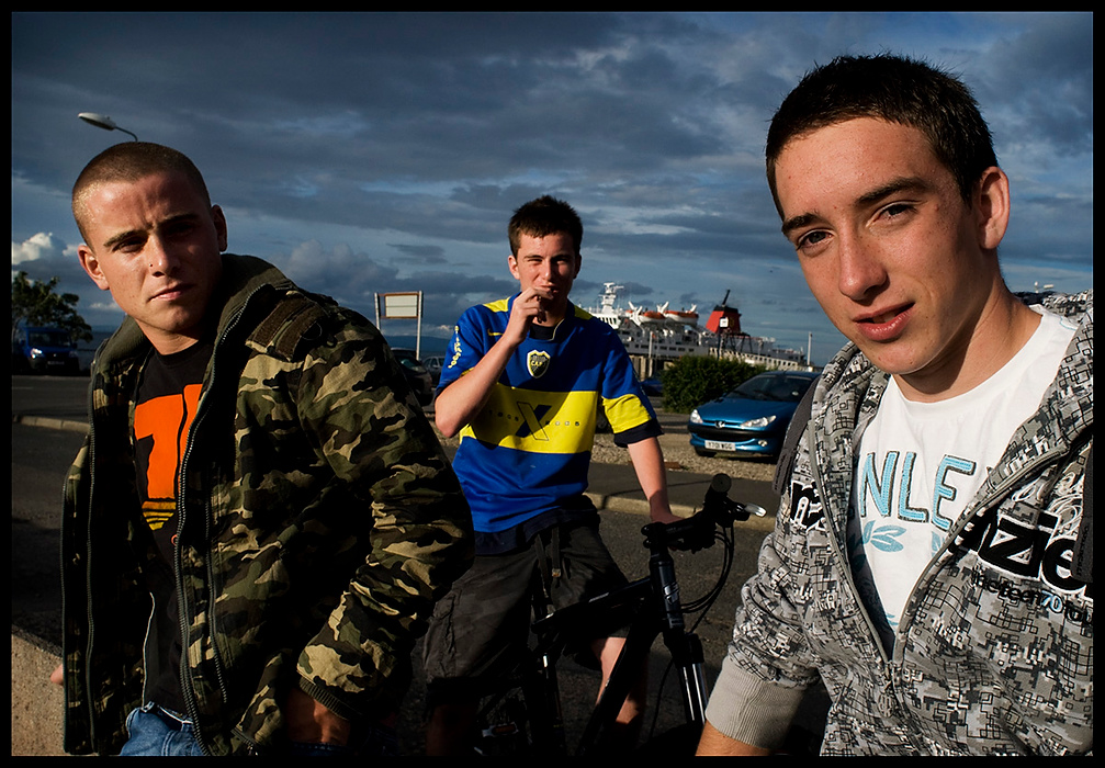 Larry Fullerton Photojournalism Scholarship - James Roh / Ohio UniversityNiall Hume, Van Smith, and Tony McDoniall (left to right) loiter outside of the Co-operative market in Brodick on.