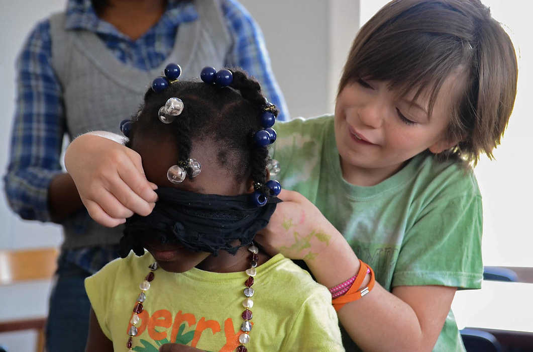 Second Place, Larry Fullerton Photojournalism Scholarship - Madison Schmidt / University of CincinnatiFrankie (right) tied a scarf around Jada's (left) eyes during a Saturday Inklings tea party at WordPlay. The group learned the value of sharing by passing around a piece of candy and taking turns guessing which friend had the candy.