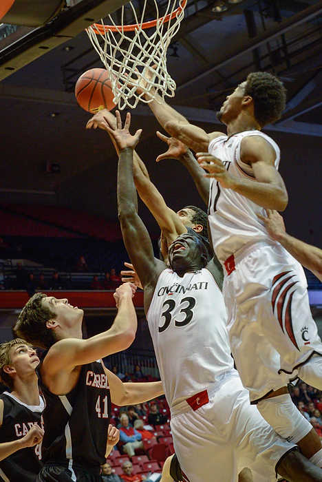 Second Place, Larry Fullerton Photojournalism Scholarship - Madison Schmidt / University of CincinnatiPlayers fight for the ball near the hoop during University of Cincinnati's exhibition game against Carleton at the Fifth Third Arena. Center David Nyarsuk reaches for the ball as a Carleton player knocks it out of the way during the rebound. The Bearcats won against the Ravens 77-63.