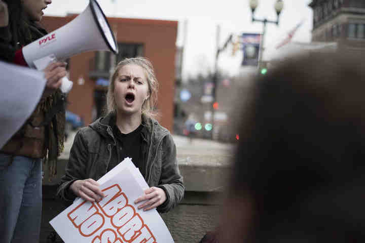 Third place, ,  - Alexandria Skowronski / Ohio UniversityMegan Carter, of Longmont, Colorado, and president of the Intersectional Feminist Alliance at Ohio University, listens as fellow IFA members speak out during the IFA Positive Rally on Court Street in Athens.  (Alexandria Skowronski/Ohio University)