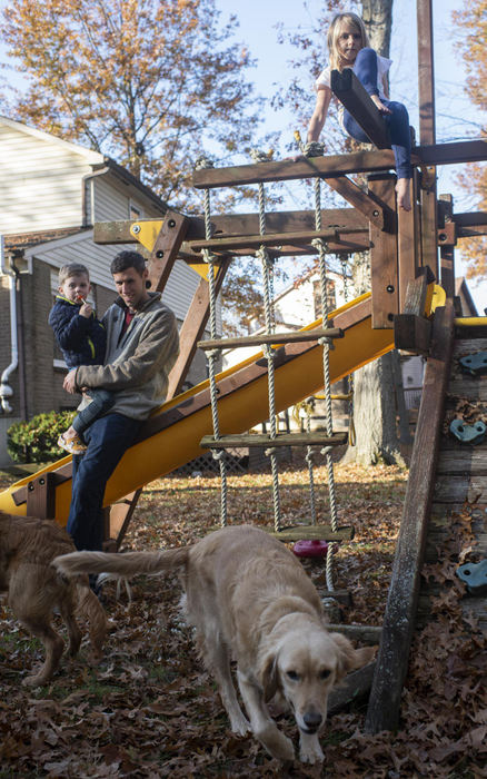 First Place - Larry Fullerton Photojournalism Scholarship , Tanner Pearson / Ohio UniversityDrew Mason holds his son, Luke, while his daughter Natalie climbs on the family playset on Nov. 11, 2020. The Mason family has two golden retrievers, Sadie and Toby. The family loves spending time outdoors and being active.