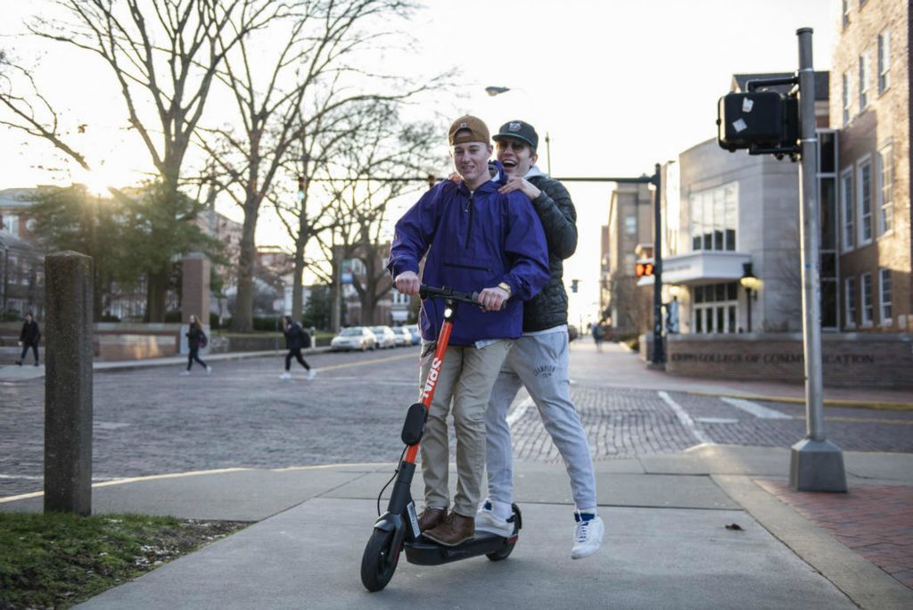 First Place - Larry Fullerton Photojournalism Scholarship , Tanner Pearson / Ohio UniversityOhio University students Brogan Lake (front) and Cord Haubert (back) ride a Spin scooter at the corner of E. Union St. and S. College St. on Feb. 19, 2020. The two travelled around campus looking for charged scooters to ride.